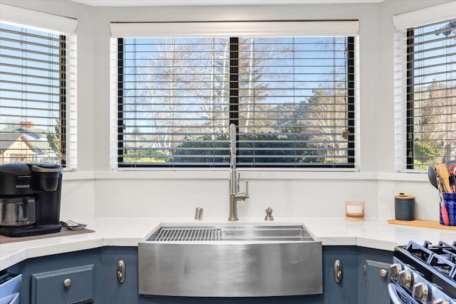 kitchen featuring blue cabinets, a healthy amount of sunlight, and light countertops