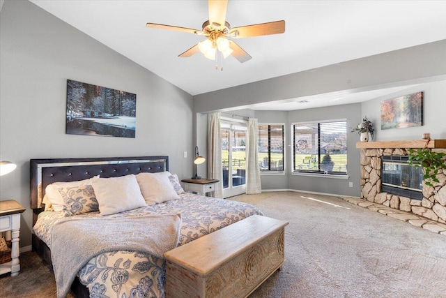 carpeted bedroom with access to exterior, baseboards, vaulted ceiling, and a stone fireplace