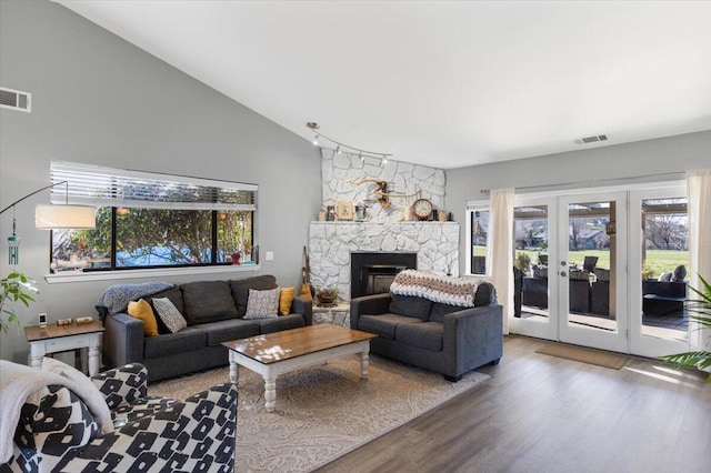 living room featuring a fireplace, visible vents, and a wealth of natural light