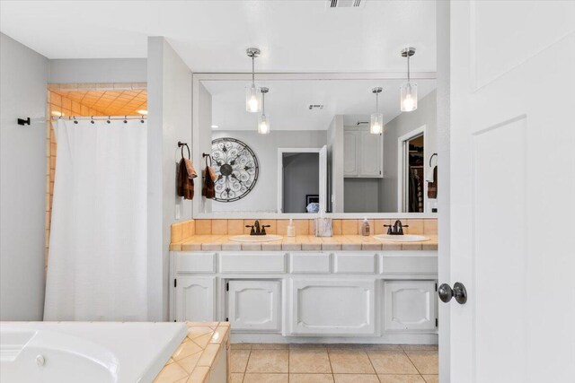 full bathroom featuring double vanity, a sink, a washtub, and tile patterned floors