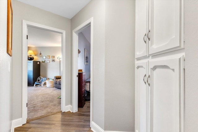 hall featuring wood finished floors and baseboards