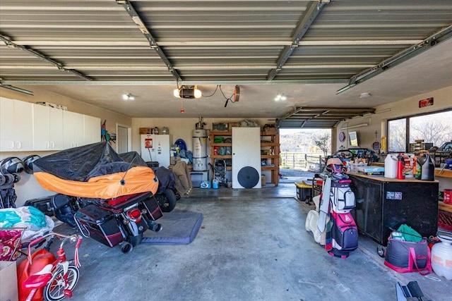 garage with strapped water heater, freestanding refrigerator, and a garage door opener