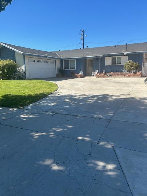 ranch-style home with a garage and a front yard