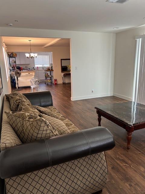 living room featuring dark wood-type flooring and a notable chandelier