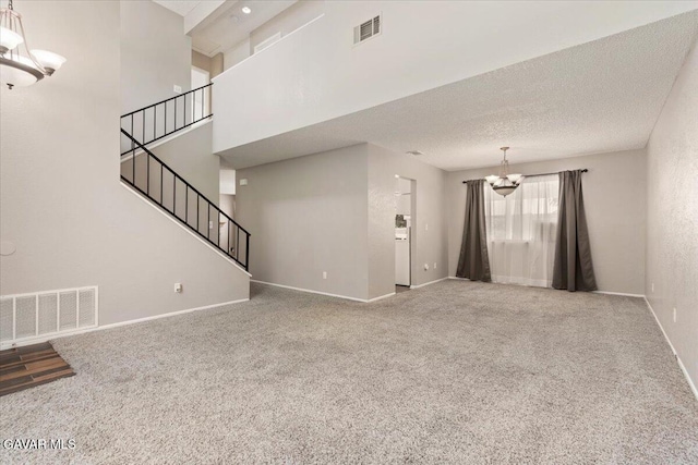 2130 Candice Ave, Rosamond, CA 93560 - unfurnished living room with a chandelier, carpet flooring, stairs, and a textured ceiling