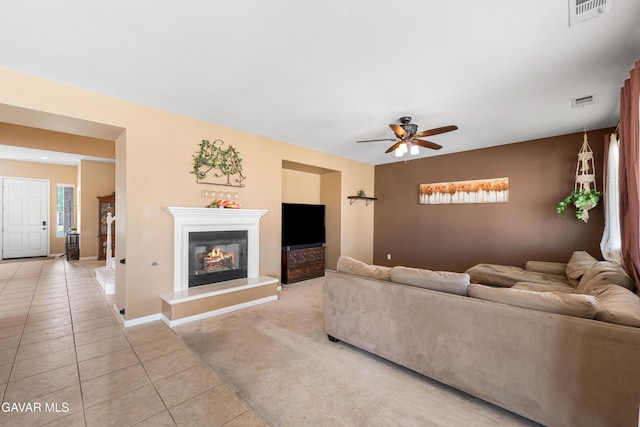 41507 Alexo Dr, Lancaster, CA 93536 - living area featuring light tile patterned floors, a ceiling fan, a glass covered fireplace, and light carpet