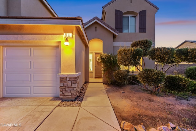 41507 Alexo Dr, Lancaster, CA 93536 - view of front of house with stucco siding, stone siding, a tiled roof, an attached garage, and driveway