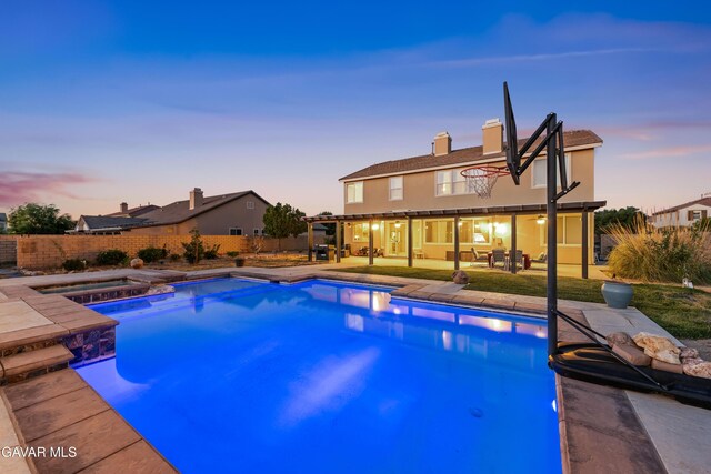 41507 Alexo Dr, Lancaster, CA 93536 - pool at dusk with a patio area, a fenced backyard, and a pool with connected hot tub