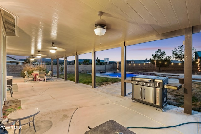 41507 Alexo Dr, Lancaster, CA 93536 - patio terrace at dusk with a patio area, a fenced backyard, outdoor dining area, and ceiling fan