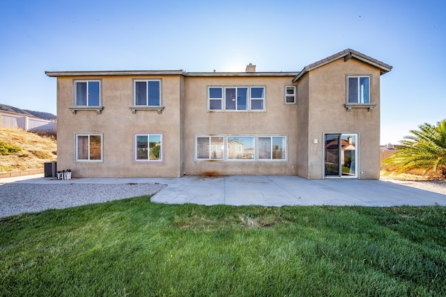 rear view of house featuring a patio, cooling unit, and a lawn