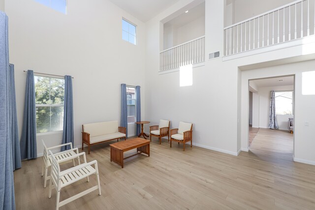 living room featuring ceiling fan, light hardwood / wood-style floors, and built in shelves