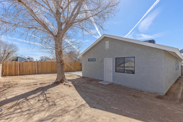 back of property with fence, a patio, and stucco siding