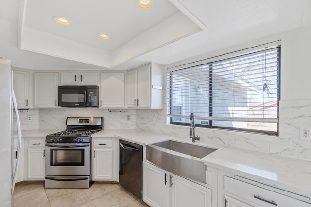 kitchen with white cabinets, black appliances, backsplash, and a sink