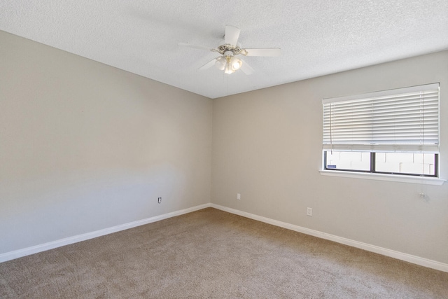 carpeted empty room featuring a ceiling fan, a textured ceiling, and baseboards