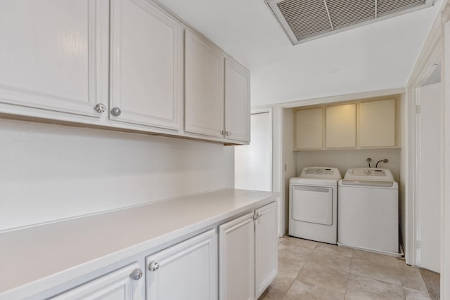 laundry room featuring cabinet space, visible vents, washer and clothes dryer, and light tile patterned flooring