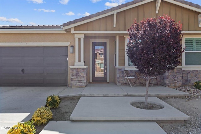 39057 Mondell Pine Ave, Palmdale, CA 93551 - view of exterior entry featuring stone siding, a garage, board and batten siding, and concrete driveway