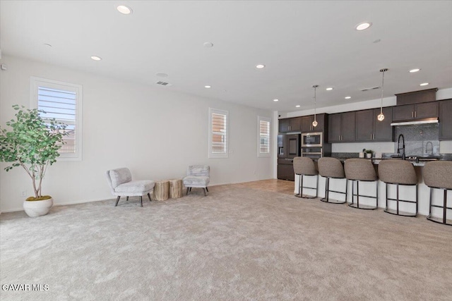 39057 Mondell Pine Ave, Palmdale, CA 93551 - kitchen with stainless steel appliances, a breakfast bar, dark brown cabinetry, recessed lighting, and light carpet