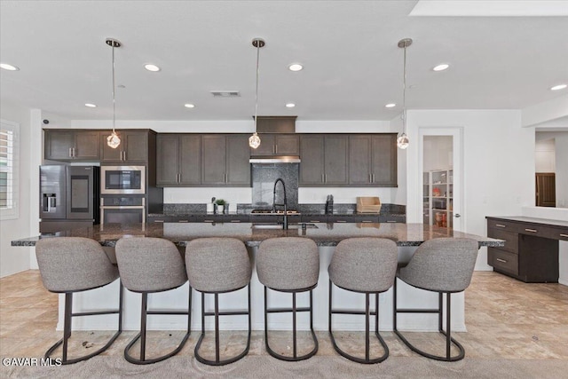 39057 Mondell Pine Ave, Palmdale, CA 93551 - kitchen with appliances with stainless steel finishes, dark brown cabinetry, recessed lighting, a breakfast bar area, and hanging light fixtures