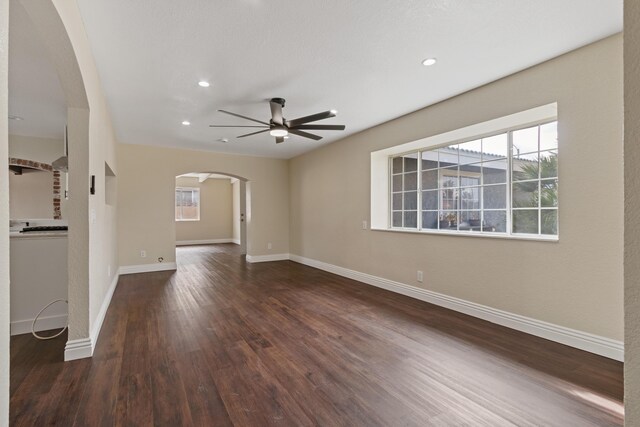 unfurnished living room with ceiling fan, a textured ceiling, dark hardwood / wood-style flooring, and a brick fireplace