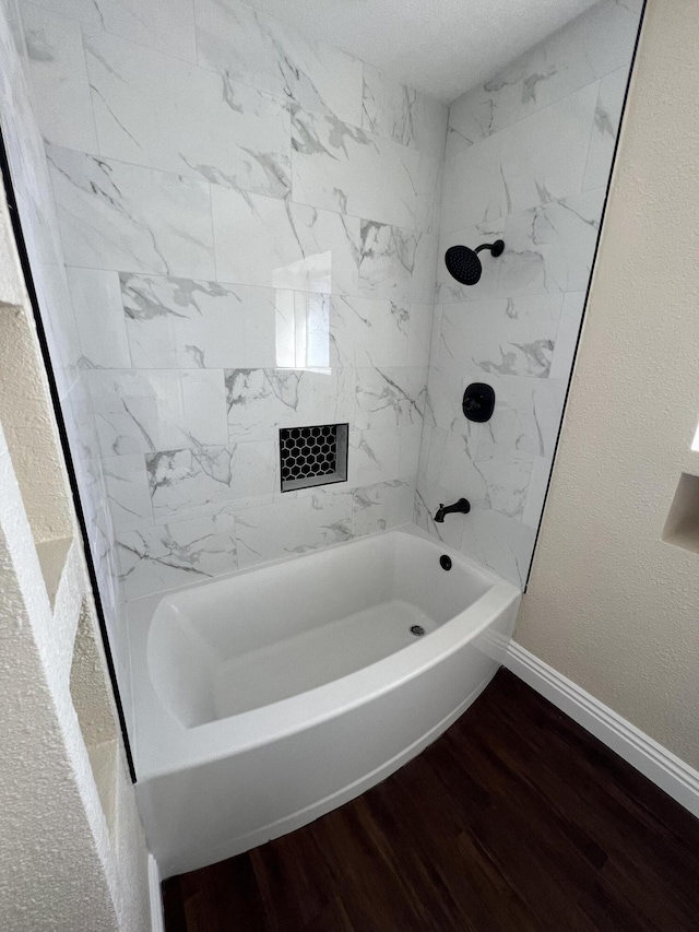 bathroom with hardwood / wood-style floors and tiled shower / bath combo