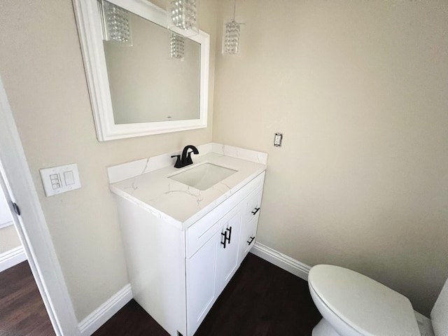 bathroom featuring hardwood / wood-style flooring, toilet, and vanity