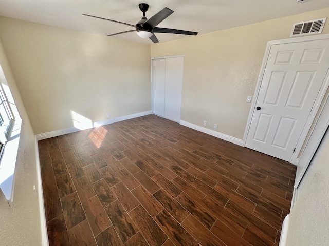 unfurnished bedroom with ceiling fan and a closet