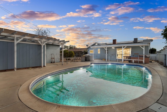 pool at dusk with a pergola and a patio