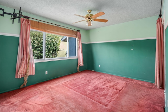 empty room with ceiling fan, carpet, and a textured ceiling