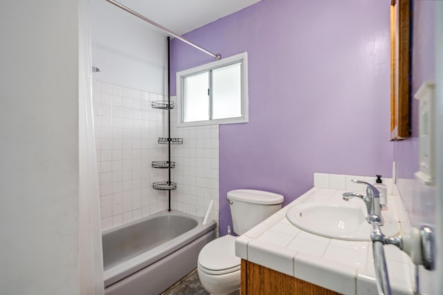 full bathroom featuring tiled shower / bath combo, vanity, and toilet