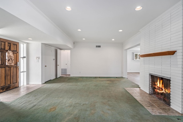 unfurnished living room with a brick fireplace, dark carpet, and ornamental molding