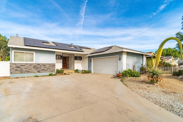 view of front of home featuring a garage and solar panels