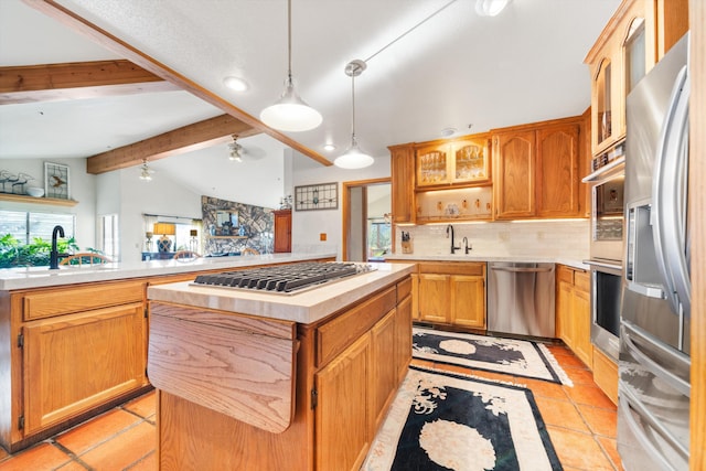 kitchen with a center island, tasteful backsplash, lofted ceiling with beams, light tile patterned flooring, and appliances with stainless steel finishes