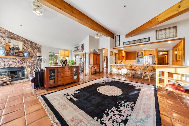 tiled living room featuring a stone fireplace, ceiling fan, and lofted ceiling with beams