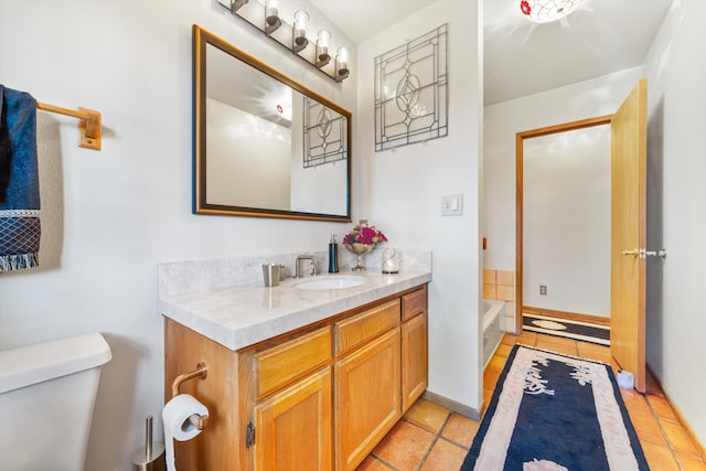 bathroom featuring tile patterned flooring, vanity, toilet, and a bathing tub