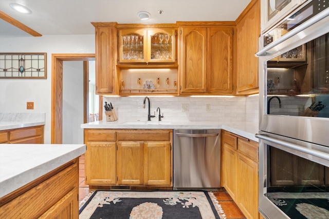 kitchen with tasteful backsplash, sink, and stainless steel appliances