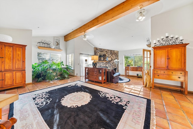 living room featuring beamed ceiling, light tile patterned flooring, a stone fireplace, and high vaulted ceiling