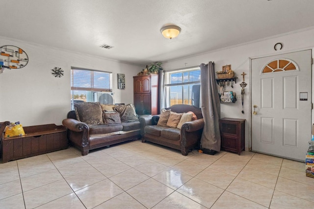 tiled living room featuring ornamental molding, a healthy amount of sunlight, and a textured ceiling