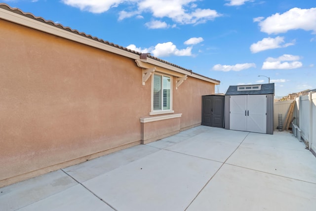 view of side of home with a shed and a patio area