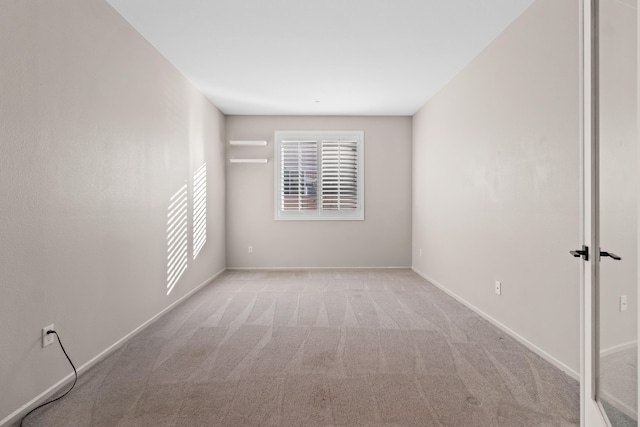 unfurnished room featuring light colored carpet