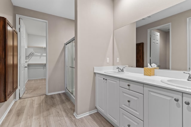 bathroom featuring a shower with shower door, vanity, and hardwood / wood-style flooring