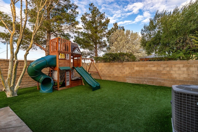 view of jungle gym with fence, central AC unit, and a lawn