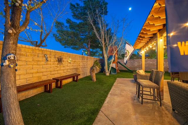 view of yard with a patio, a playground, and a fenced backyard