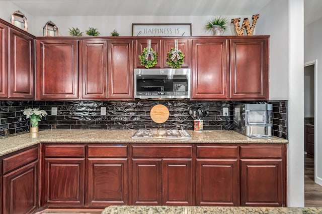 kitchen with stainless steel appliances, tasteful backsplash, and dark brown cabinets