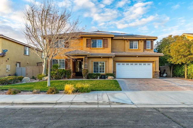 view of front of house featuring solar panels, a front yard, an attached garage, and fence