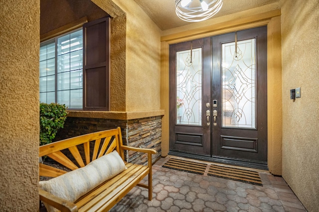 foyer with french doors and a textured wall