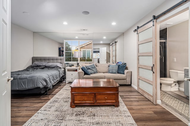 bedroom featuring recessed lighting, a barn door, baseboards, and dark wood-type flooring