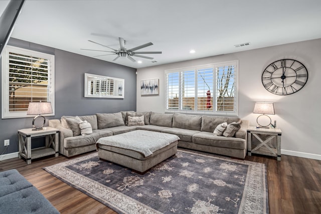 living area with visible vents, baseboards, wood finished floors, and a ceiling fan