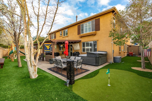 rear view of property featuring fence, stucco siding, a hot tub, a playground, and a patio area