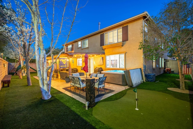 back of property with an outdoor living space, stucco siding, a lawn, a fenced backyard, and a patio area