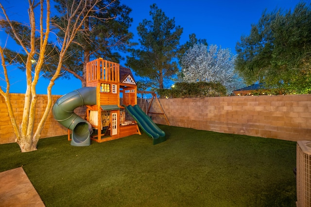 view of play area featuring central air condition unit, a lawn, and a fenced backyard